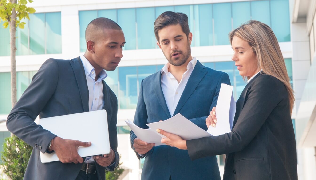 female professional explaining report to male colleagues (1) female professional explaining report to male colleagues